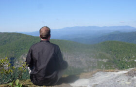 man on mountain meditating